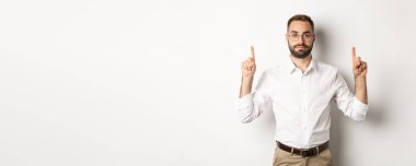 Genç sakallı iş adamı, beyaz arka planda duran reklam teklifini gösteriyor. Boşluğu kopyala