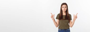 Gri arka planda yalnız duran mutlu ve şaşırmış genç bir bayan portresi. Kamera işaret ediyor