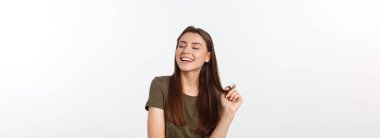 Şaşırdım. Kadın yana bakıyor. Heyecandan yana bakan mutlu genç bir kadın. Gri arka planda Asyalı ve beyaz ırk beyaz kadın modeli.