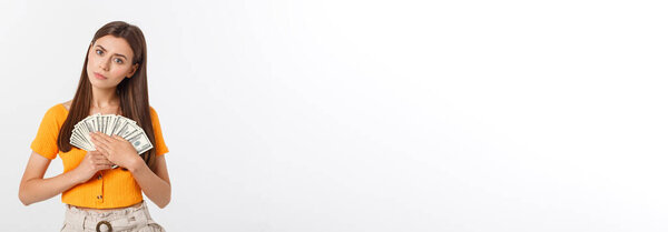 Photo of happy young woman standing isolated over grey background. Looking aside holding money and credit card.