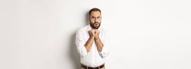 Korkmuş ve ürkek iş adamı endişeli görünüyor, korkudan titriyor, beyaz arka planda duruyor..