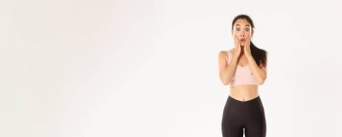 Spor, refah ve aktif yaşam tarzı konsepti. Şaşırmış ve şaşırmış Asyalı tatlı fitness kızı logonuza ya da etkilenmiş yüzünüze bakıyor, mağazadaki özel indirimi duyuyor..