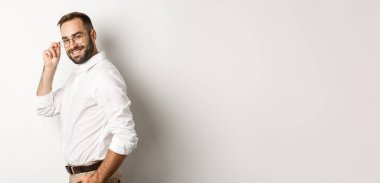 Yakışıklı iş adamı kameraya döndü ve kendine güvenen, küstah, beyaz arka planda duran.