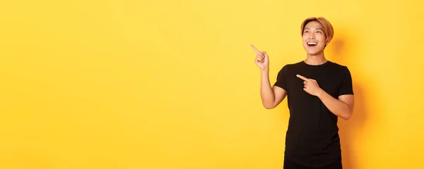 Portret Zadowolonego Przystojnego Azjaty Czarnej Koszulce Wytykającego Palcami Wyglądającego Lewym — Zdjęcie stockowe