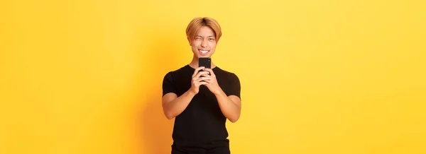 Стильный Красивый Азиатский Парень Фотографирующий Смартфоне Улыбающийся Фотографирующий Мобильным Телефоном — стоковое фото