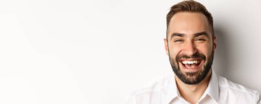 Duygular ve insan konsepti. Gülen, gülümseyen, neşeli, beyaz arka planda mutlu bir adamın portresi..