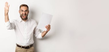 Kızgın işadamı bağırıyor ve kötü rapor veriyor, hayal kırıklığına uğramış ve hayal kırıklığına uğramış görünüyor, beyaz arka planda duruyor..