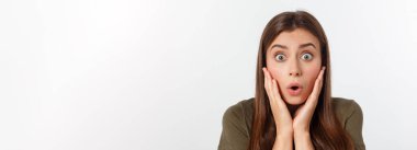 Şaşırmış ve ağzı açık bir şekilde kafasını tutan güzel bir kızın yakın plan portresi. Beyaz arkaplan.