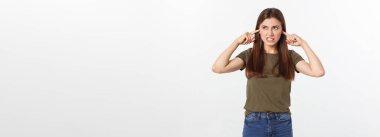 Kulaklarını tıkayan kızgın genç bir kadının yakın plan portresi, şu gürültüyü kes. Başımı ağrıtıyor, beyaz arka planda izole edilmiş.
