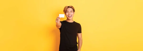 Alegre Guapo Asiático Chico Sonriendo Complacido Mostrando Tarjeta Crédito Pie — Foto de Stock