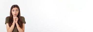 Şaşırmış ve ağzı açık bir şekilde kafasını tutan güzel bir kızın yakın plan portresi. Beyaz arkaplan.