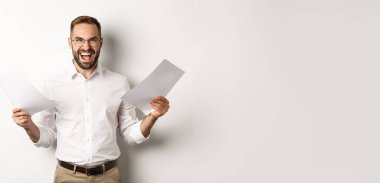 Kızgın patron belgelerle hayal kırıklığına uğradı, kızgın ve agresif, beyaz arka planda duruyor..
