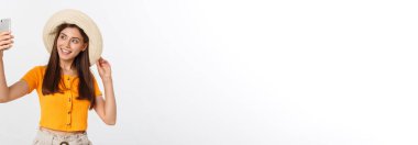 Beyaz arka planda yaz seyahati kavramında tek başına selfie çeken genç beyaz bir kadın.