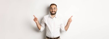 Kararsız işadamı iki varyantı gösteriyor, seçim yapmakta zorlanıyor, beyaz arka planda duruyor..