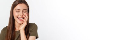 Şaşırdım. Kadın yana bakıyor. Heyecandan yana bakan mutlu genç bir kadın. Gri arka planda Asyalı ve beyaz ırk beyaz kadın modeli.