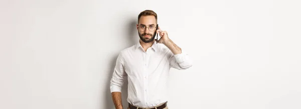 Homem Negócios Confiante Falando Telefone Olhando Sério Sobre Fundo Branco — Fotografia de Stock