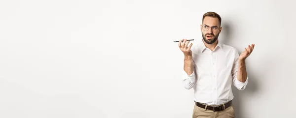 Homem Gravando Mensagem Voz Falando Alto Falante Olhando Confuso Sobre — Fotografia de Stock