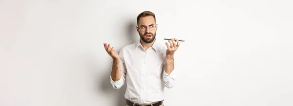 Homem Gravando Mensagem Voz Falando Alto Falante Olhando Confuso Sobre — Fotografia de Stock