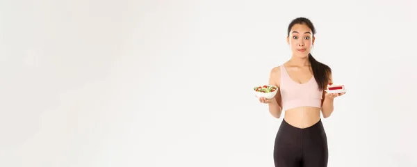 활동적 선수의 선수는 정크푸드를 건강에 샐러드와 케이크를 다이어트를 유혹을 물리친다 — 스톡 사진