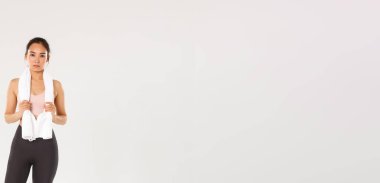 Spor, spor salonu ve sağlıklı vücut konsepti. Tam boy odaklı ve kararlı genç kız atlet, havluyla sporcu kadın üretken egzersizlerden sonra ayakta duruyor, spor egzersizlerinden terliyor..