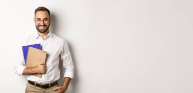 Elinde defterler, e-öğrenim konsepti ve kurslar tutan genç yakışıklı adam..