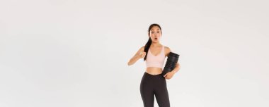 Etkilenmiş ve tatmin olmuş Asyalı bayan sporcu, spor kıyafetli kız başparmaklarını kaldırıyor ve 