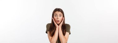 Şaşırmış ve ağzı açık bir şekilde kafasını tutan güzel bir kızın yakın plan portresi. Beyaz arkaplan.