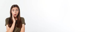 Şaşırdım. Kadın yana bakıyor. Heyecandan yana bakan mutlu genç bir kadın. Gri arka planda Asyalı ve beyaz ırk beyaz kadın modeli.