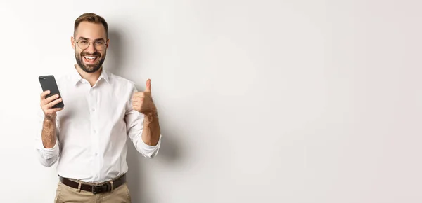 Задоволений Бізнесмен Який Показує Великі Пальці Після Використання Мобільного Телефону — стокове фото