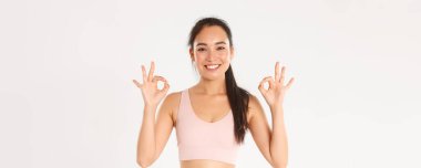Spor, refah ve aktif yaşam tarzı konsepti. Gülümseyen, tatmin olmuş Asyalı sporcu kadın spor salonu ya da yoga dersleri öneriyor..