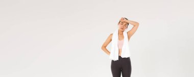 Spor, spor salonu ve sağlıklı vücut konsepti. Spor salonundaki fitness antrenmanından sonra yorgun hisseden, havluyla duran, koluyla terleyen yorgun Asyalı kız..