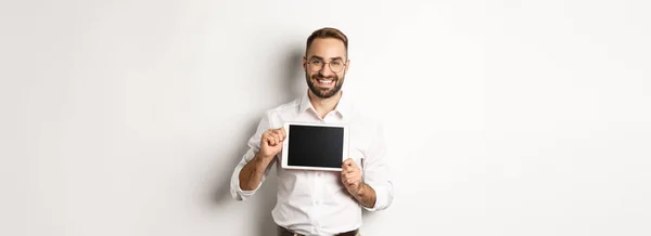 ショッピングと技術 白い襟のシャツとメガネを身に着けているデジタルタブレット画面を示すハンサムな男 スタジオの背景 — ストック写真