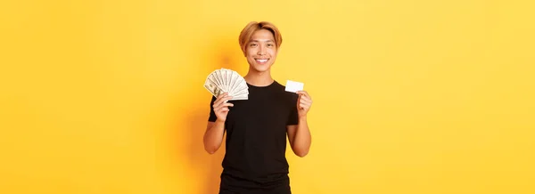 Příjemný Pohledný Asijský Chlap Ukazující Peníze Kreditní Kartu Šťastný Úsměv — Stock fotografie