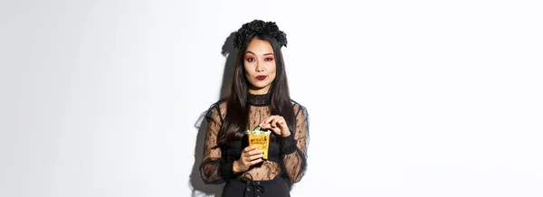 Confident Smiling Asian Woman Looking Satisfied Holding Sweets Wearing Witch — Stock Photo, Image