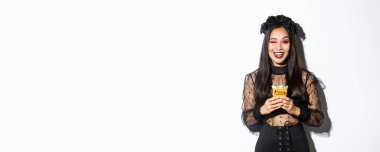 Cadı kostümlü küstah kız, Cadılar Bayramı 'nı kutluyor, gotik elbiseyle şeker toplamaya gidiyor, dil gösteriyor ve şeker tutuyor..