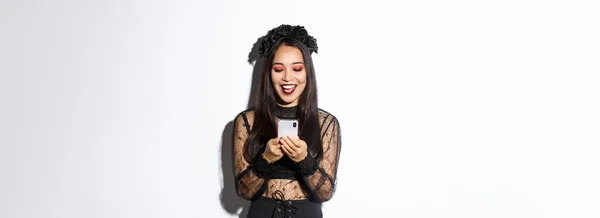 Heyecanlı Gülümseyen Bir Kadın Cep Telefonuna Bakarken Mutlu Cadılar Bayramı — Stok fotoğraf