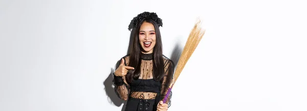 Portrait Attractive Woman Witch Costume Celebrating Halloween Pointing Broom Standing — Stock Photo, Image