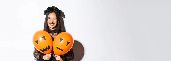 Imagem Menina Asiática Traje Bruxa Mal Segurando Dois Balões Laranja — Fotografia de Stock