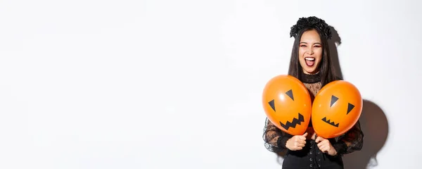 Imagen Chica Asiática Traje Bruja Malvada Sosteniendo Dos Globos Naranjas — Foto de Stock