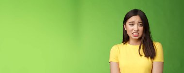 Endişeli, tatlı Asyalı kız esmer dişlerini sıkan, korkudan titreyen, suçlu görünen, sinirli, cezayı bekleyen, yeşil geçmişi olan, mahcup bir kız. Boşluğu kopyala