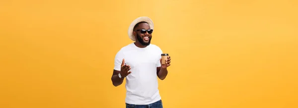 时尚的年轻非洲裔美国男子拿着一杯带走的咖啡孤立在黄色背景 — 图库照片