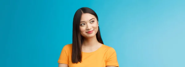 特写梦幻般的迷人的年轻亚洲女人穿着黄色T恤 面带微笑兴高采烈 凝视着窗外美丽的夏景 无忧无虑地坐在办公室外 蓝色背景 — 图库照片