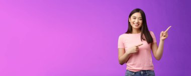 Neşeli, cana yakın, güler yüzlü Asyalı kız tanıtım yapıyor, yeni ürünleri tanıtıyor, neşeyle sırıtıyor havalı reklamlar sunuyor, pembe tişörtlü, pembe tişörtlü, arka planda eğleniyor..