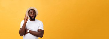 Sarı bir arka plan üzerinde izole boşaltmak bakarak bardaklarda dalgın bir afro Amerikalı adam portresi.