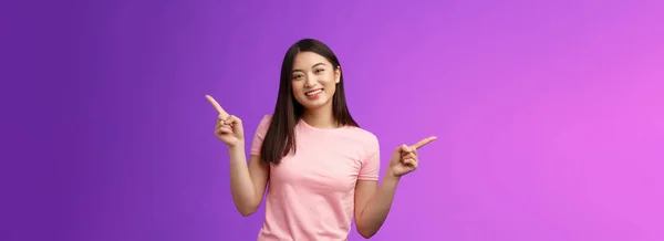 迷人的放松可爱的亚洲女人剪短短发横向介绍多种选择 展示左右产品 快乐地微笑 容易做出决定 站在紫色背景上 — 图库照片