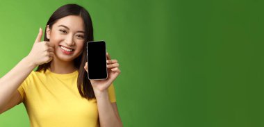 Yakın plan tatminkar Asyalı kız olumlu geri bildirim veriyor, akıllı telefon ekranı gösteriyor, harika yeni bir uygulama tanıtıyor, iyi uygulama öneriyor, maçta övünerek skor yapıyor..