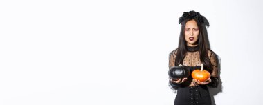 Surat asan, balkabağı atan, cadılar bayramını kutlayan, beyaz arka planda duran kızgın cadının görüntüsü..