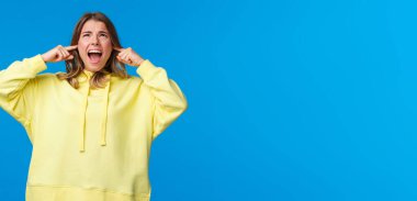 Kapat şu berbat müziği. Sinirlenmiş ve rahatsız olmuş kızgın sarışın kız tavana bağırıyor ve komşulara gürültüyü kesmelerini, kulaklarını gürültüden uzak tutmalarını söylüyor..