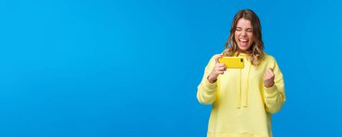 İnternette canlı yayında cep telefonu kullanarak, kazanarak, takım golünü atarak, evet sevinçle, mavi arka planda oyunu izleyen genç kızı tatmin etmek ve memnun etmek..