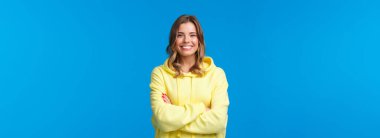 Hadi iş konuşalım. Kendine güvenen, güler yüzlü, gülümseyen, mükemmel gülüşlü, elleri çapraz göğüslü, görevlere hazır, patronun talimatlarını dinleyen, mavi arka planda sarı kapüşonlu bir kadın..